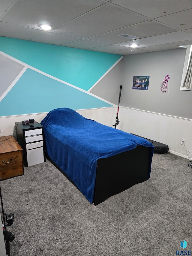 carpeted bedroom featuring a drop ceiling