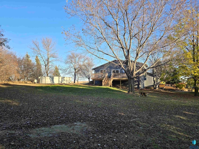 view of yard featuring a deck and a storage unit