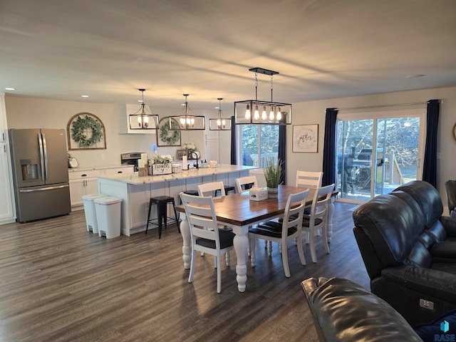 dining space with dark wood-type flooring and an inviting chandelier