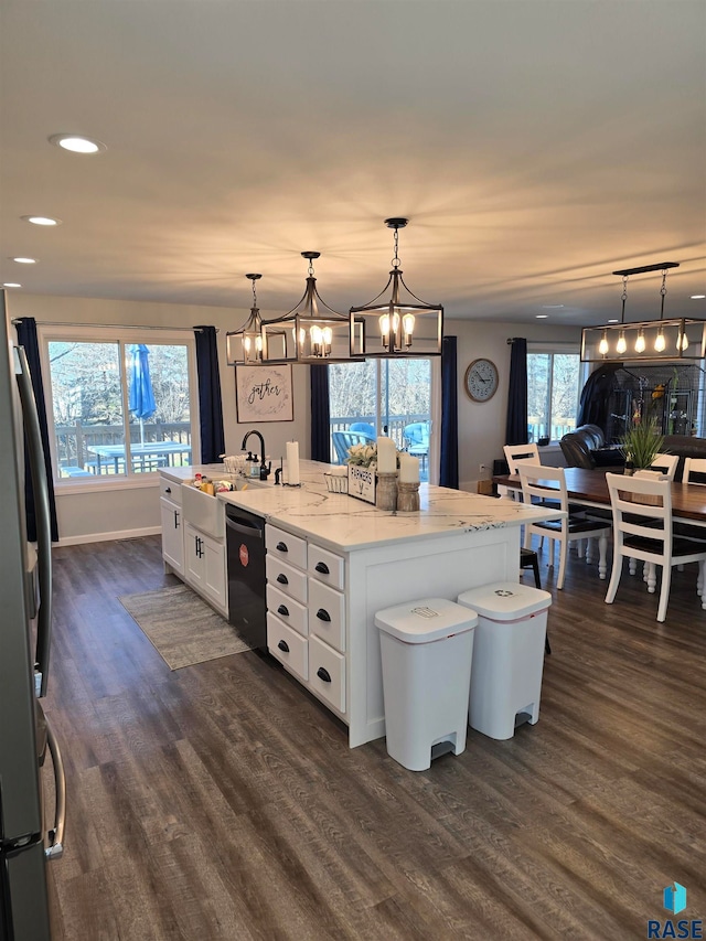 kitchen with white cabinetry, decorative light fixtures, a kitchen island with sink, stainless steel fridge, and dishwasher