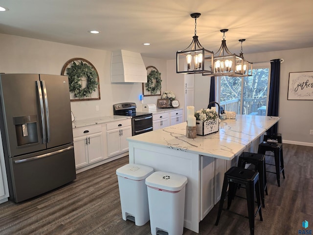 kitchen with premium range hood, stainless steel appliances, pendant lighting, white cabinets, and a kitchen island with sink