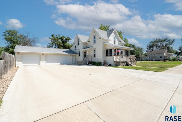 view of front of home featuring a garage, a front yard, and covered porch