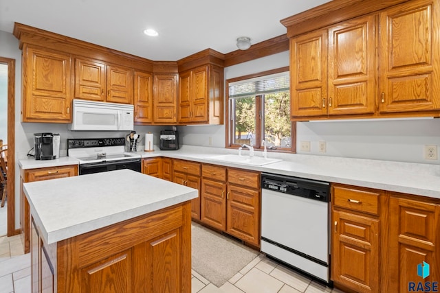 kitchen with sink, white appliances, a center island, and light tile patterned floors