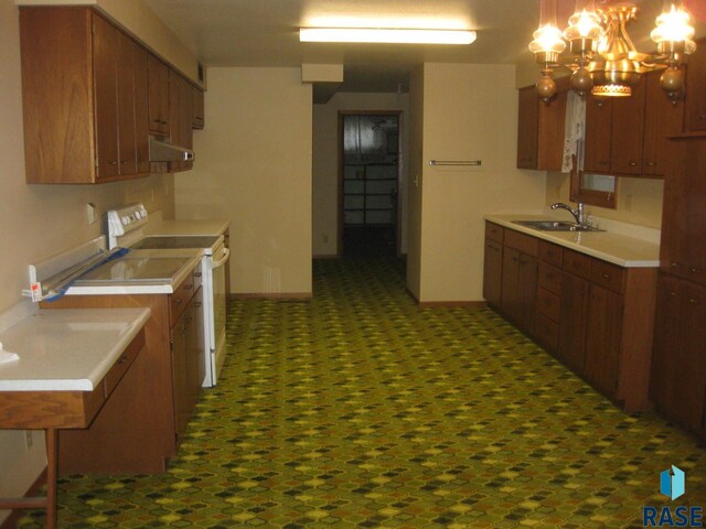 kitchen featuring hanging light fixtures, sink, a chandelier, and electric range