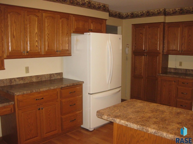 kitchen with hardwood / wood-style floors and white refrigerator