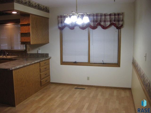 kitchen featuring hanging light fixtures, a chandelier, sink, and light hardwood / wood-style flooring