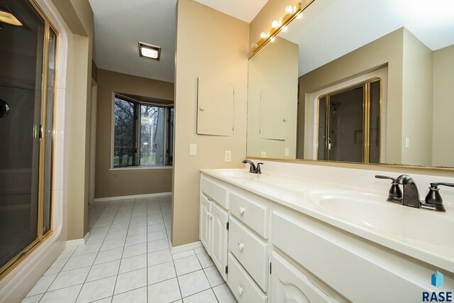 bathroom featuring vanity, a shower with shower door, and tile patterned floors