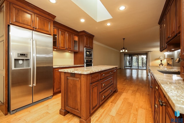 kitchen with appliances with stainless steel finishes, pendant lighting, light hardwood / wood-style flooring, and crown molding