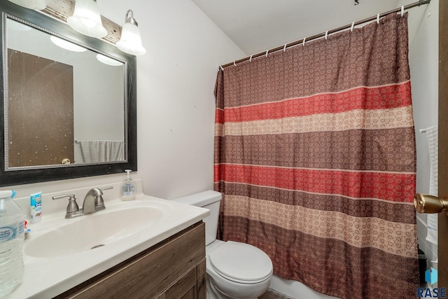 bathroom with curtained shower, vanity, and toilet