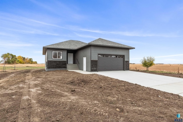 prairie-style home featuring a rural view and a garage