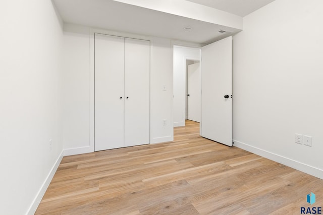 unfurnished bedroom featuring light hardwood / wood-style floors and a closet