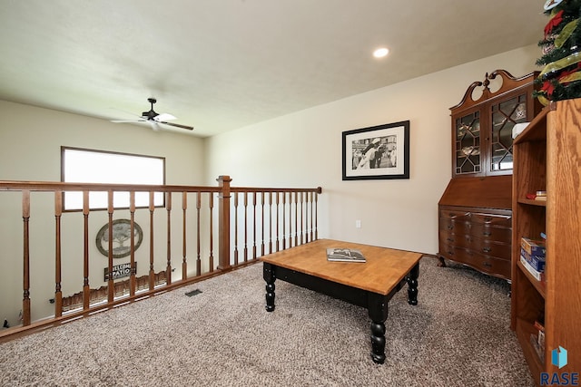 interior space with dark carpet and ceiling fan