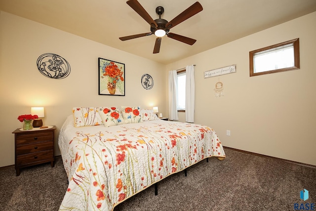 bedroom with ceiling fan, dark carpet, and multiple windows