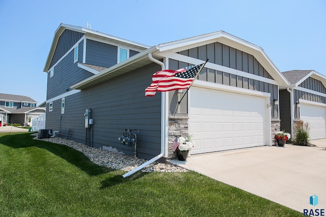 view of home's exterior featuring a lawn, cooling unit, and a garage