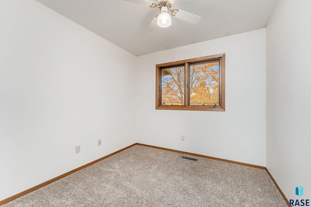 empty room featuring carpet, ceiling fan, and a textured ceiling