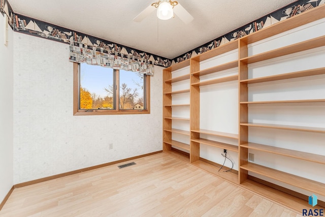 interior space featuring ceiling fan, wood-type flooring, and a textured ceiling