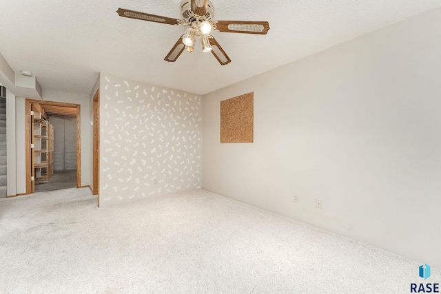 unfurnished room with ceiling fan, carpet, and a textured ceiling