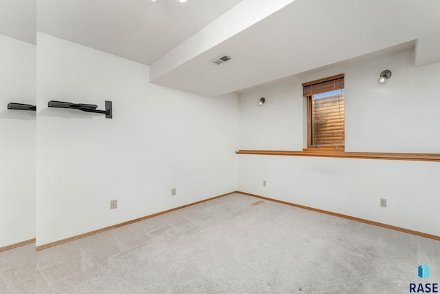 carpeted spare room with a textured ceiling