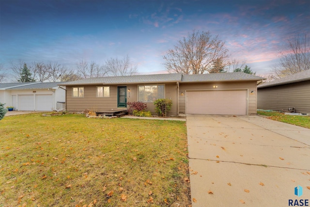 single story home featuring a lawn and a garage