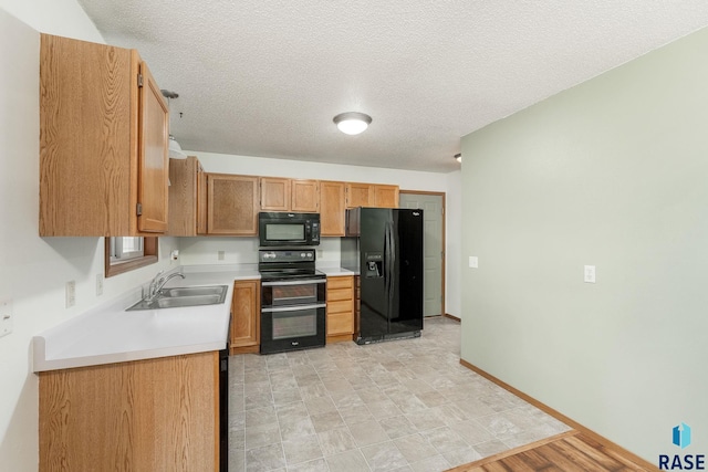 kitchen with a textured ceiling, sink, light hardwood / wood-style floors, and black appliances