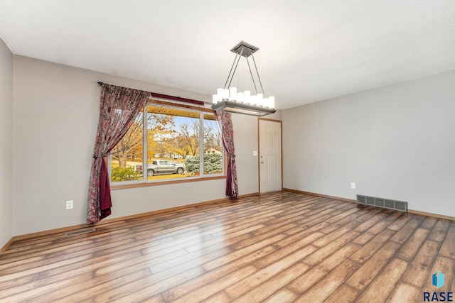 spare room with light hardwood / wood-style flooring and a textured ceiling