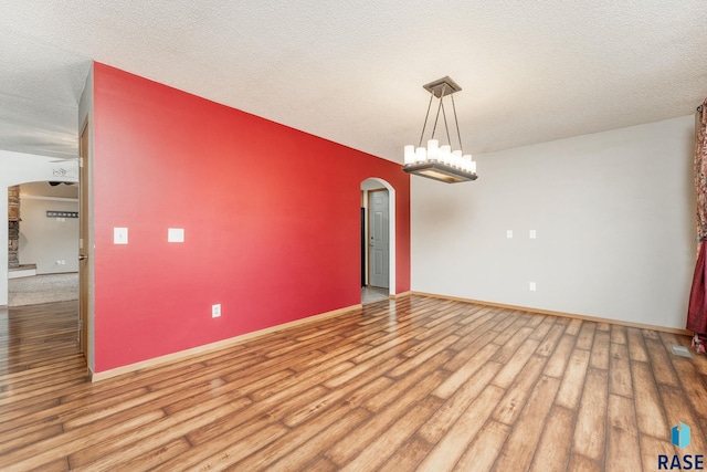 unfurnished room featuring wood-type flooring and a textured ceiling