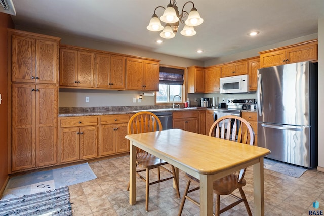 kitchen with a chandelier, sink, stainless steel appliances, and decorative light fixtures