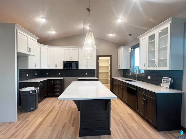 kitchen with sink, decorative light fixtures, black dishwasher, a kitchen island, and white cabinets