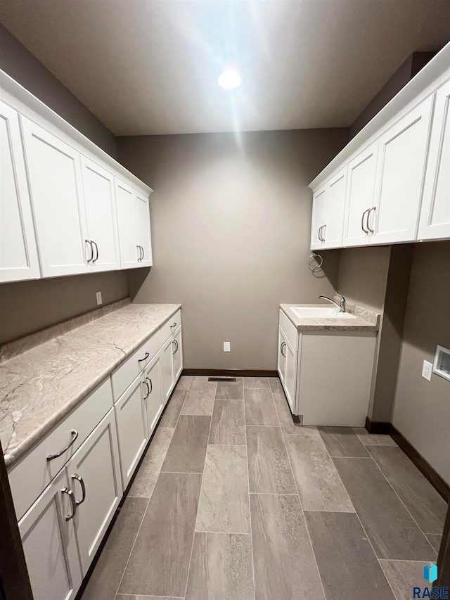 laundry room with cabinets and sink