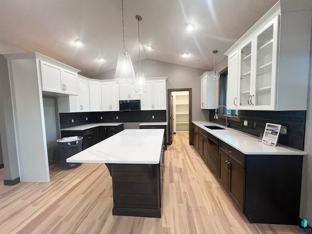 kitchen featuring lofted ceiling, sink, light hardwood / wood-style flooring, a kitchen island, and white cabinets