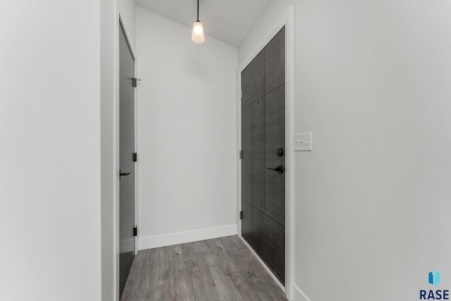 corridor featuring hardwood / wood-style flooring and vaulted ceiling