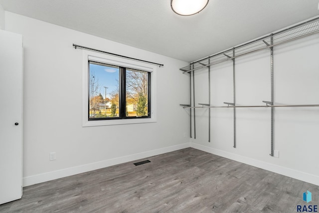 unfurnished room featuring hardwood / wood-style flooring and a textured ceiling