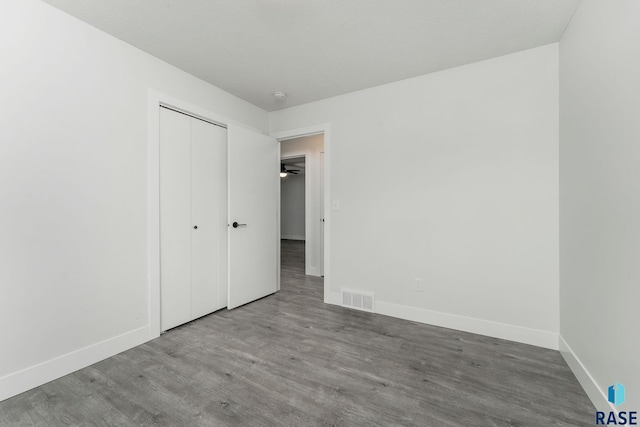 unfurnished bedroom with wood-type flooring and a closet