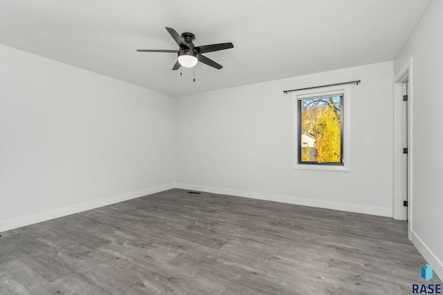 empty room with hardwood / wood-style flooring, ceiling fan, and a textured ceiling