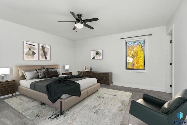 bedroom with ceiling fan, wood-type flooring, and a textured ceiling