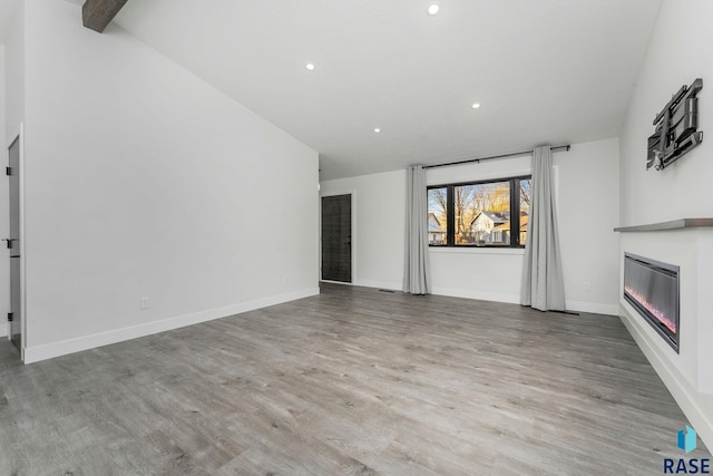 unfurnished living room featuring light hardwood / wood-style floors and vaulted ceiling