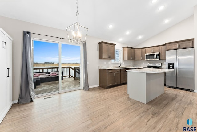 kitchen featuring sink, a kitchen island, stainless steel appliances, and light hardwood / wood-style flooring