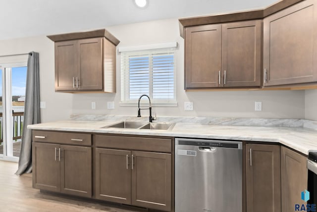 kitchen with light stone counters, white range, sink, dishwasher, and light hardwood / wood-style floors