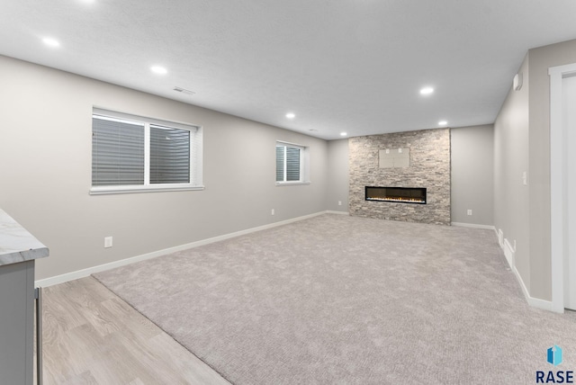 unfurnished living room featuring light wood-type flooring and a fireplace