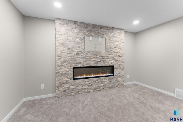 unfurnished living room with light colored carpet and a fireplace