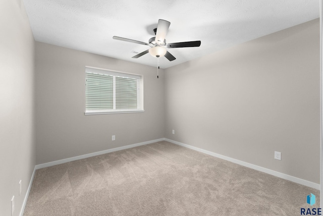 spare room with ceiling fan, carpet, and a textured ceiling