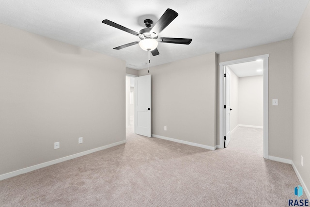 unfurnished bedroom featuring ceiling fan, light colored carpet, and a textured ceiling