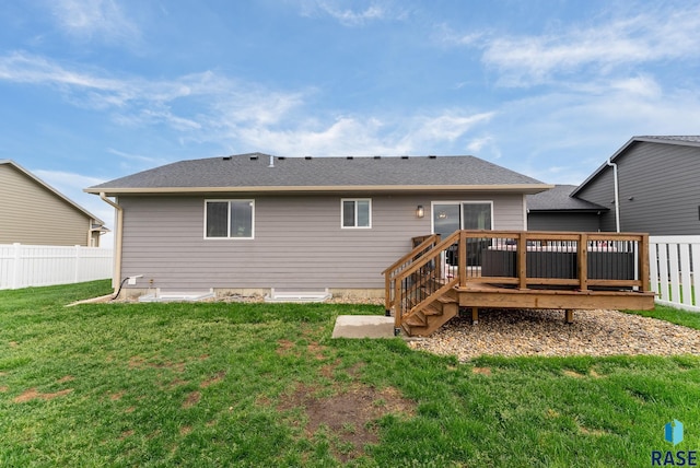 back of property featuring a deck and a yard