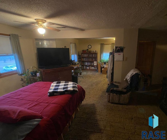 carpeted bedroom with a textured ceiling and ceiling fan