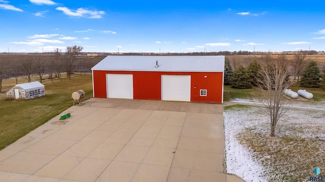 view of outdoor structure featuring a yard, a rural view, and a garage