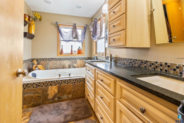 bathroom featuring vanity and tiled tub