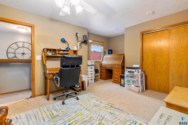 office space featuring ceiling fan, light colored carpet, and a textured ceiling