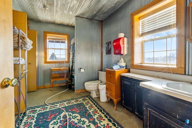 bathroom featuring sink, concrete flooring, and toilet