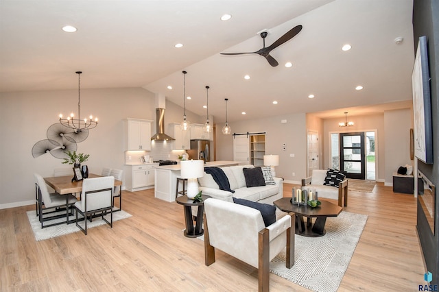 living room featuring a barn door, vaulted ceiling, and light wood-type flooring