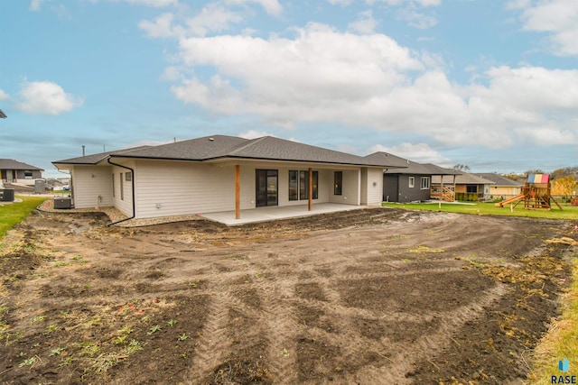 rear view of house with a patio area and a playground